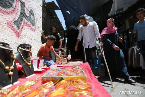Palestinian disabled Mohammed Al Akhras, 32, who lost his leg by Israeli troops during clashes at Gaza-Israel border uses his crutch to walk at market as he shopping ahead of Eid al-Fitr holiday, in Rafah in the southern...