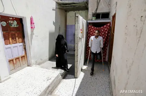 Palestinian disabled Mohammed Al Akhras, 32, who lost his leg by Israeli troops during clashes at Gaza-Israel border uses his crutch to walk at his home before he going to market ahead of Eid al-Fitr holiday, in Rafah in...