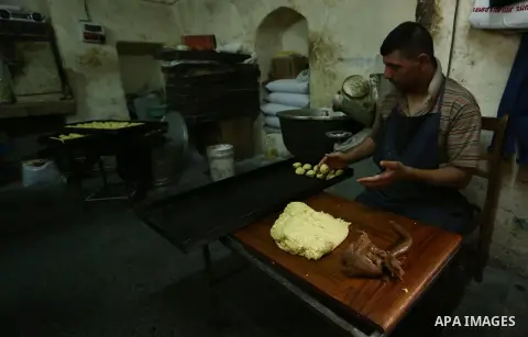 Palestinians prepare traditional date-filled mini cakes to sell for customers ahead of Eid al-Fitr holiday in the West Bank city of Nablus on June 14, 2018. Eid al-Fitr marks the end of Muslim's holy fasting month of Ram...