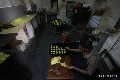 Palestinians prepare traditional date-filled mini cakes to sell for customers ahead of Eid al-Fitr holiday in the West Bank city of Nablus on June 14, 2018. Eid al-Fitr marks the end of Muslim's holy fasting month of Ram...