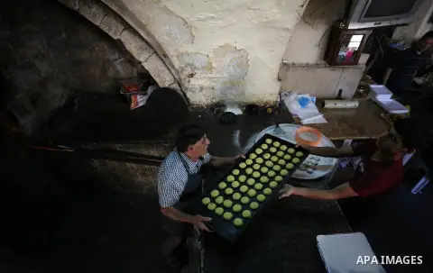 Palestinians prepare traditional date-filled mini cakes to sell for customers ahead of Eid al-Fitr holiday in the West Bank city of Nablus on June 14, 2018. Eid al-Fitr marks the end of Muslim's holy fasting month of Ram...