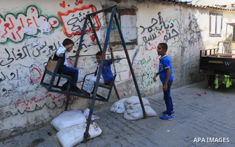 Palestinian children enjoy the first day of Eid al-Fitr holiday which marks the end of the Muslim holy month of Ramadan, in al-Bureij in the center of Gaza Strip on June 15, 2018. Eid al-Fitr marks the end of Muslim's ho...