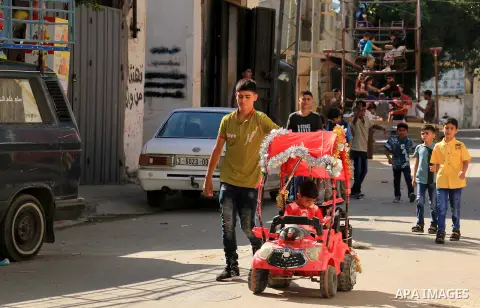 Palestinian children enjoy the first day of Eid al-Fitr holiday which marks the end of the Muslim holy month of Ramadan, in al-Bureij in the center of Gaza Strip on June 15, 2018. Eid al-Fitr marks the end of Muslim's ho...
