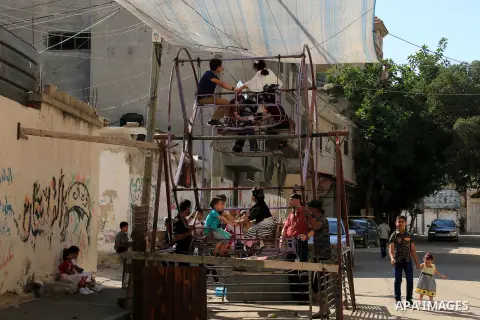 Palestinian children enjoy the first day of Eid al-Fitr holiday which marks the end of the Muslim holy month of Ramadan, in al-Bureij in the center of Gaza Strip on June 15, 2018. Eid al-Fitr marks the end of Muslim's ho...