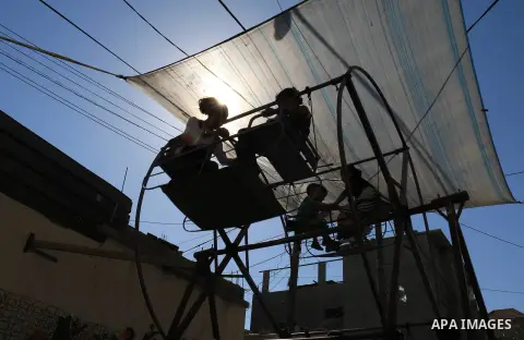Palestinian children enjoy the first day of Eid al-Fitr holiday which marks the end of the Muslim holy month of Ramadan, in al-Bureij in the center of Gaza Strip on June 15, 2018. Eid al-Fitr marks the end of Muslim's ho...
