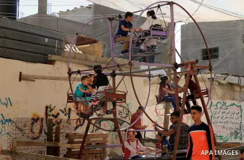 Palestinian children enjoy the first day of Eid al-Fitr holiday which marks the end of the Muslim holy month of Ramadan, in al-Bureij in the center of Gaza Strip on June 15, 2018. Eid al-Fitr marks the end of Muslim's ho...