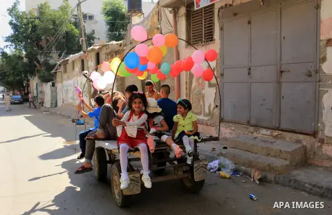Palestinian children enjoy the first day of Eid al-Fitr holiday which marks the end of the Muslim holy month of Ramadan, in al-Bureij in the center of Gaza Strip on June 15, 2018. Eid al-Fitr marks the end of Muslim's ho...