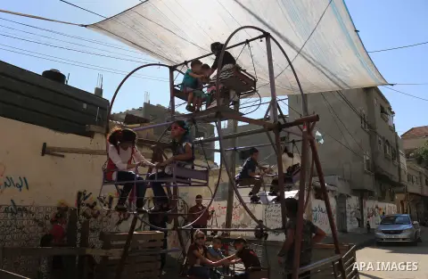 Palestinian children enjoy the first day of Eid al-Fitr holiday which marks the end of the Muslim holy month of Ramadan, in al-Bureij in the center of Gaza Strip on June 15, 2018. Eid al-Fitr marks the end of Muslim's ho...