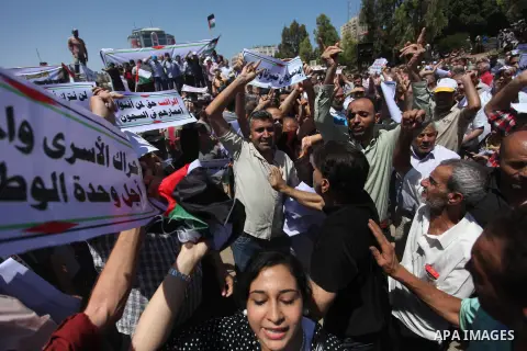 People chant slogans during a protest calling on President Mahmoud Abbas to end financial sanctions on Palestinians in Gaza, in Gaza City, on June 18, 2018. Demonstrators called Fatah and Hamas movements to reconcile. Ph...