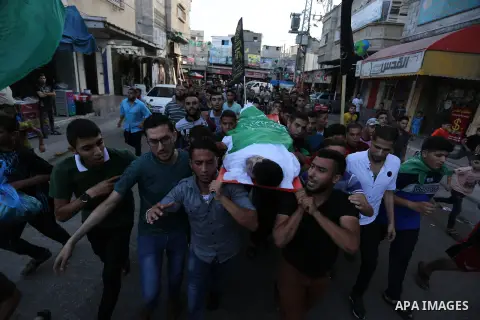 Mourners carry the body of Palestinian of Zakaria Beshbesh, 13, who died of his wounds endured during clashes with Israeli troops in a tent city protest where Palestinians demand the right to return to their homeland at...
