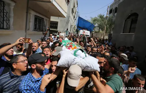 Mourners carry the body of Palestinian Mohammed Abu Daqqa, 24, who died of wounds he sustained during clashes with Israeli troops, during his funeral in Khan Younis in the southern of Gaza Strip on June 21, 2018. Photo b...