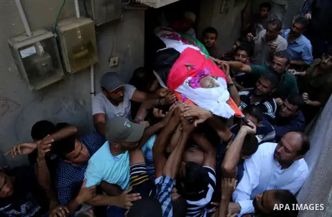Mourners carry the body of Palestinian Osama Abu Khater, who died of wounds he sustained during clashes with Israeli troops, his funeral in Khan Younis in the southern Gaza Strip on June 24, 2018. Photo by Ashraf Amra