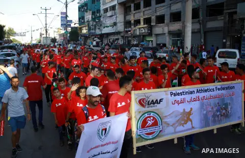 Palestinian scouts take part in a march marking the Palestinian Olympic Day, in Gaza city, on June 24, 2018. Photo by Bashar Zakri