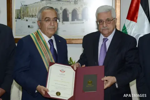 (FILES) This file photo taken on June 8, 2013 shows Palestinian President Mahmoud Abbas (Abu Mazen) honors former Prime Minister Salam Fayyad in the West Bank city of Ramallah. According to media, a sudden meeting was he...