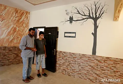 The father of Palestinian blind Saleh Ashour, 16, who lost his sight by Israeli troops during clashes at Gaza-Israel border, helps him to walk in Nusseirat refugee camp in the center of Gaza Strip on July 1, 2018. Photo...