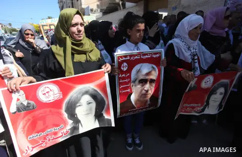 Palestinians take part a protest to show solidarity with the Leftist Legislator Khaleda Jarrar, in front of Red cross office in Gaza city on July 2, 2018. Photo by Mahmoud Ajour