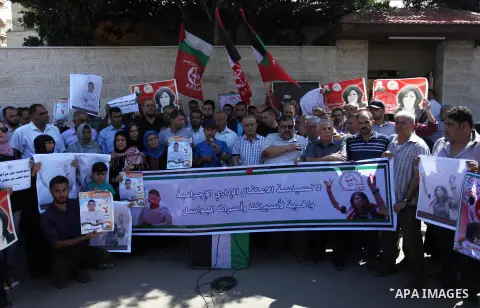 Palestinians take part a protest to show solidarity with the Leftist Legislator Khaleda Jarrar, in front of Red cross office in Gaza city on July 2, 2018. Photo by Mahmoud Ajour