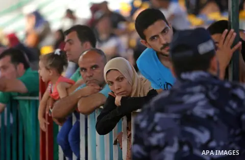 Palestinians wait for travel permits to cross into Egypt through the Rafah border crossing in Khan Yunis in the southern Gaza Strip on July 2, 2018. Photo by Ashraf Amra