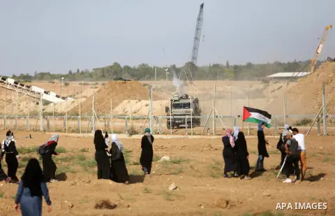 Palestinian women gather during a protest where Palestinians demand the right to return to their homeland along the border with Israel east of Gaza City on July 3, 2018. Photo by Ashraf Amra