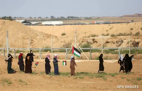 Palestinian women gather during a protest where Palestinians demand the right to return to their homeland along the border with Israel east of Gaza City on July 3, 2018. Photo by Ashraf Amra