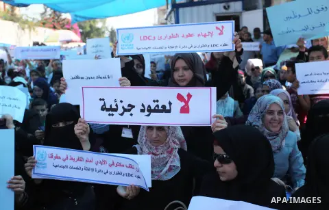 Palestinians hold banners during in a protest against a U.S. decision to cut aid, in front of the headquarters United Nations Relief and Works Agency (UNRWA), in Gaza City on July 4, 2018. Photo by Mahmoud Ajour