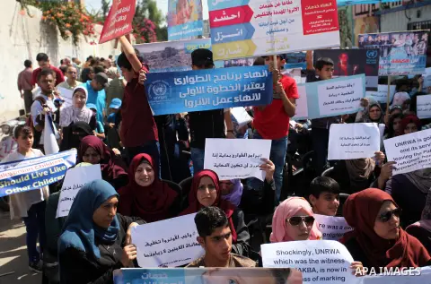 Palestinians hold banners during in a protest against a U.S. decision to cut aid, in front of the headquarters United Nations Relief and Works Agency (UNRWA), in Gaza City on July 4, 2018. Photo by Mahmoud Ajour
