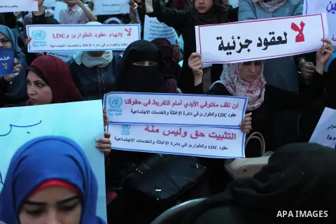 Palestinians hold banners during in a protest against a U.S. decision to cut aid, in front of the headquarters United Nations Relief and Works Agency (UNRWA), in Gaza City on July 4, 2018. Photo by Mahmoud Ajour