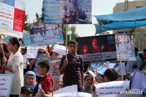Palestinians hold banners during in a protest against a U.S. decision to cut aid, in front of the headquarters United Nations Relief and Works Agency (UNRWA), in Gaza City on July 4, 2018. Photo by Mahmoud Ajour