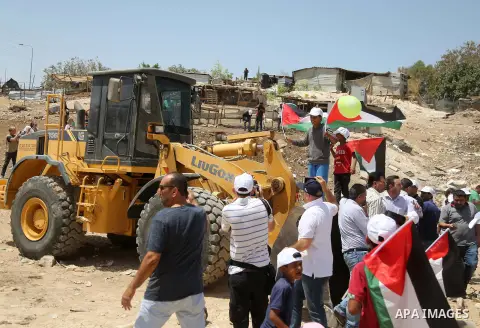 Palestinian demonstrators try to prevent a tractor from passing through in the Palestinian Bedouin village of Khan al-Ahmar, east of Jerusalem in the occupied West Bank on July 4, 2018. Residents and activists voiced con...
