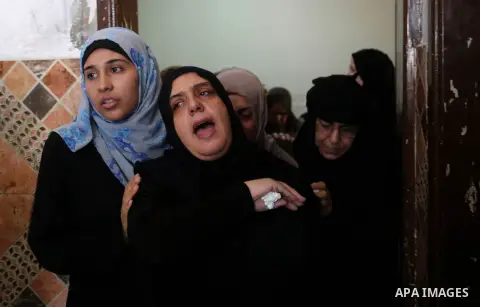 Relatives of Palestinian Mahmoud al-Ghrabli ,16, who died of wounds he sustained during clashes with Israeli troops, mourn during his funeral in Gaza city on July 5, 2018. Photo by Ashraf Amra