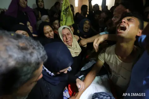 Relatives of Palestinian Mahmoud al-Ghrabli ,16, who died of wounds he sustained during clashes with Israeli troops, mourn during his funeral in Gaza city on July 5, 2018. Photo by Ashraf Amra