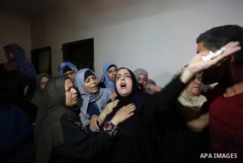 Relatives of Palestinian Mahmoud al-Ghrabli ,16, who died of wounds he sustained during clashes with Israeli troops, mourn during his funeral in Gaza city on July 5, 2018. Photo by Ashraf Amra