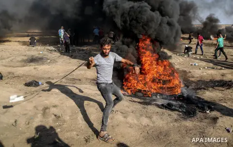 Palestinian protesters gather during clashes with Israeli troops in tents protest where Palestinian demand the right to return to their homeland at the Israel-Gaza border, in east of Gaza City on July 6, 2018. Photo by D...