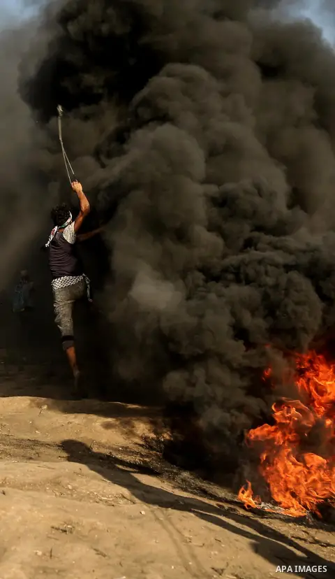 Palestinian protesters gather during clashes with Israeli troops in tents protest where Palestinian demand the right to return to their homeland at the Israel-Gaza border, in east of Gaza City on July 6, 2018. Photo by D...