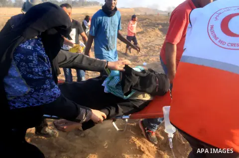 A wounded Palestinian female protester is evacuated during clashes with Israeli troops in tents protest where Palestinian demand the right to return to their homeland at the Israel-Gaza border, in al-Bureij in the center...