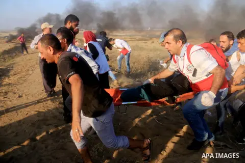 A wounded Palestinian female protester is evacuated during clashes with Israeli troops in tents protest where Palestinian demand the right to return to their homeland at the Israel-Gaza border, in al-Bureij in the center...