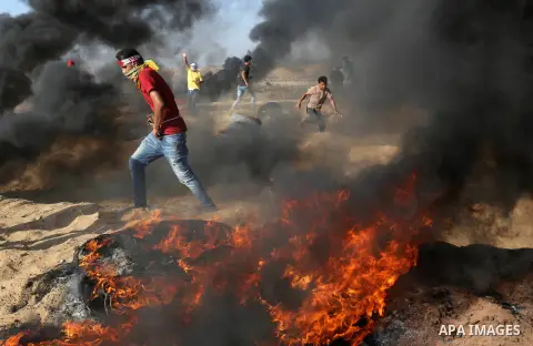 Palestinian protesters gather during clashes with Israeli troops in tents protest where Palestinian demand the right to return to their homeland at the Israel-Gaza border, in Khan Younis in the southern Gaza Strip on Jul...