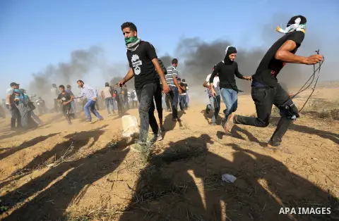 Palestinian protesters gather during clashes with Israeli troops in tents protest where Palestinian demand the right to return to their homeland at the Israel-Gaza border, in Khan Younis in the southern Gaza Strip on Jul...