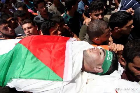 Mourners carry the body of Palestinian Mohammed Abu Halima, 22, who was shot dead by Israeli troops during clashes at Gaza-Israel border, during his funeral in Gaza city on July 7, 2018. Photo by Mahmoud Ajour