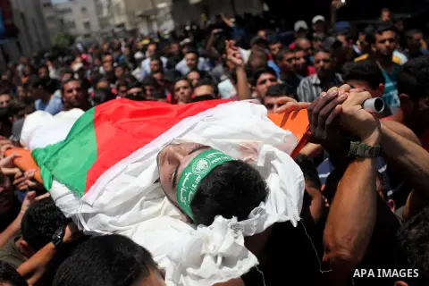 Mourners carry the body of Palestinian Mohammed Abu Halima, 22, who was shot dead by Israeli troops during clashes at Gaza-Israel border, during his funeral in Gaza city on July 7, 2018. Photo by Mahmoud Ajour