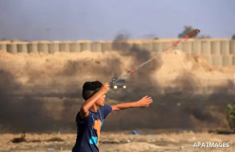 Palestinian protesters gather during clashes with Israeli troops in tents protest where Palestinian demand the right to return to their homeland at the Israel-Gaza border, in al-Bureij in the center of Gaza Strip on July...