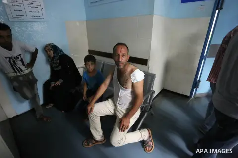 An injured Palestinan man set on a hospital bed after an Israeli air strik on the Gaza city, on July 14, 2018. At least two Palestinians were killed after an Israeli air strike hit an empty building in Gaza City. Photo b...