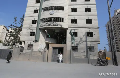 A Palestinian man walks near Ministry of Awqaf building that was damaged in an Israeli airstrike on the Gaza City, on July 15, 2018. At least two Palestinians were killed after an Israeli air strike hit an empty building...