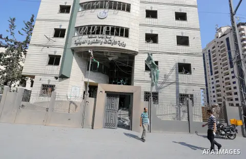A Palestinian man walks near Ministry of Awqaf building that was damaged in an Israeli airstrike on the Gaza City, on July 15, 2018. At least two Palestinians were killed after an Israeli air strike hit an empty building...
