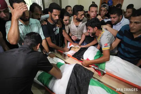 Relatives of two Palestinians, who were killed in an Israeli air strike, mourn over their bodies during their funeral at a mosque in Gaza city on July 15, 2018. Photo by Mahmoud Ajour