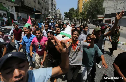Mourners carry the body of Palestinian Louay Kahil, who was killed in an Israeli air strike, during his funeral in Gaza city on July 15, 2018. Photo by Ashraf Amra