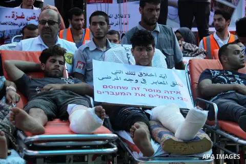 Palestinians who were wounded by Israeli troops during clashes at Israeli-Gaza border, take part in a protest to demand their rights to travel for treatment and against the siege on the Gaza Strip, at Erez crossing, in t...