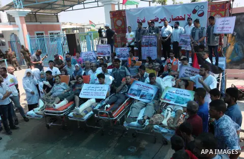 Palestinians who were wounded by Israeli troops during clashes at Israeli-Gaza border, take part in a protest to demand their rights to travel for treatment and against the siege on the Gaza Strip, at Erez crossing, in t...
