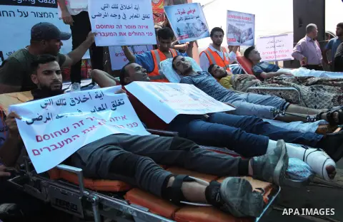 Palestinians who were wounded by Israeli troops during clashes at Israeli-Gaza border, take part in a protest to demand their rights to travel for treatment and against the siege on the Gaza Strip, at Erez crossing, in t...