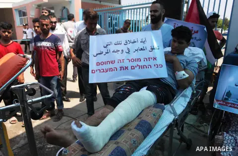 Palestinians who were wounded by Israeli troops during clashes at Israeli-Gaza border, take part in a protest to demand their rights to travel for treatment and against the siege on the Gaza Strip, at Erez crossing, in t...
